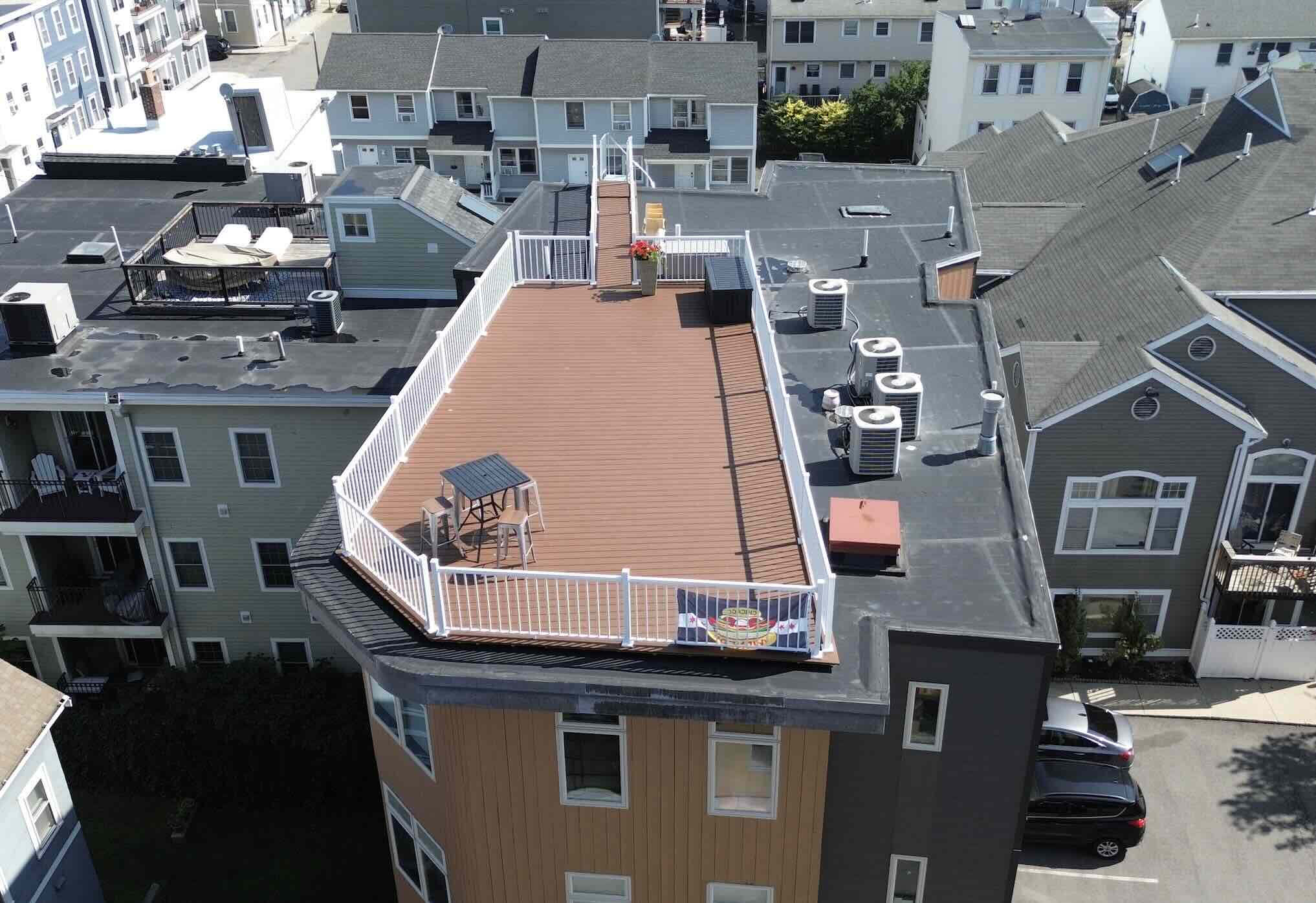 Aerial view of the commercial composite deck installation with white railing and outdoor living furniture in worcester ma