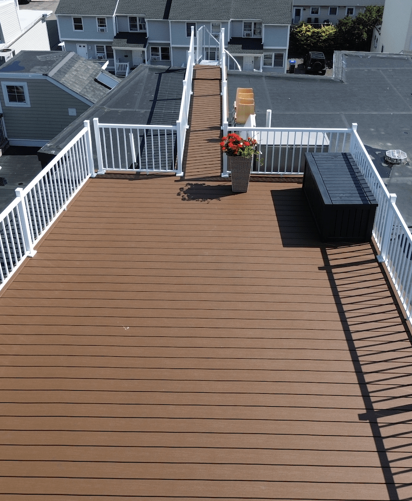 Aerial view of the commercial deck on the roof with white aluminum railing and plants in worcester ma