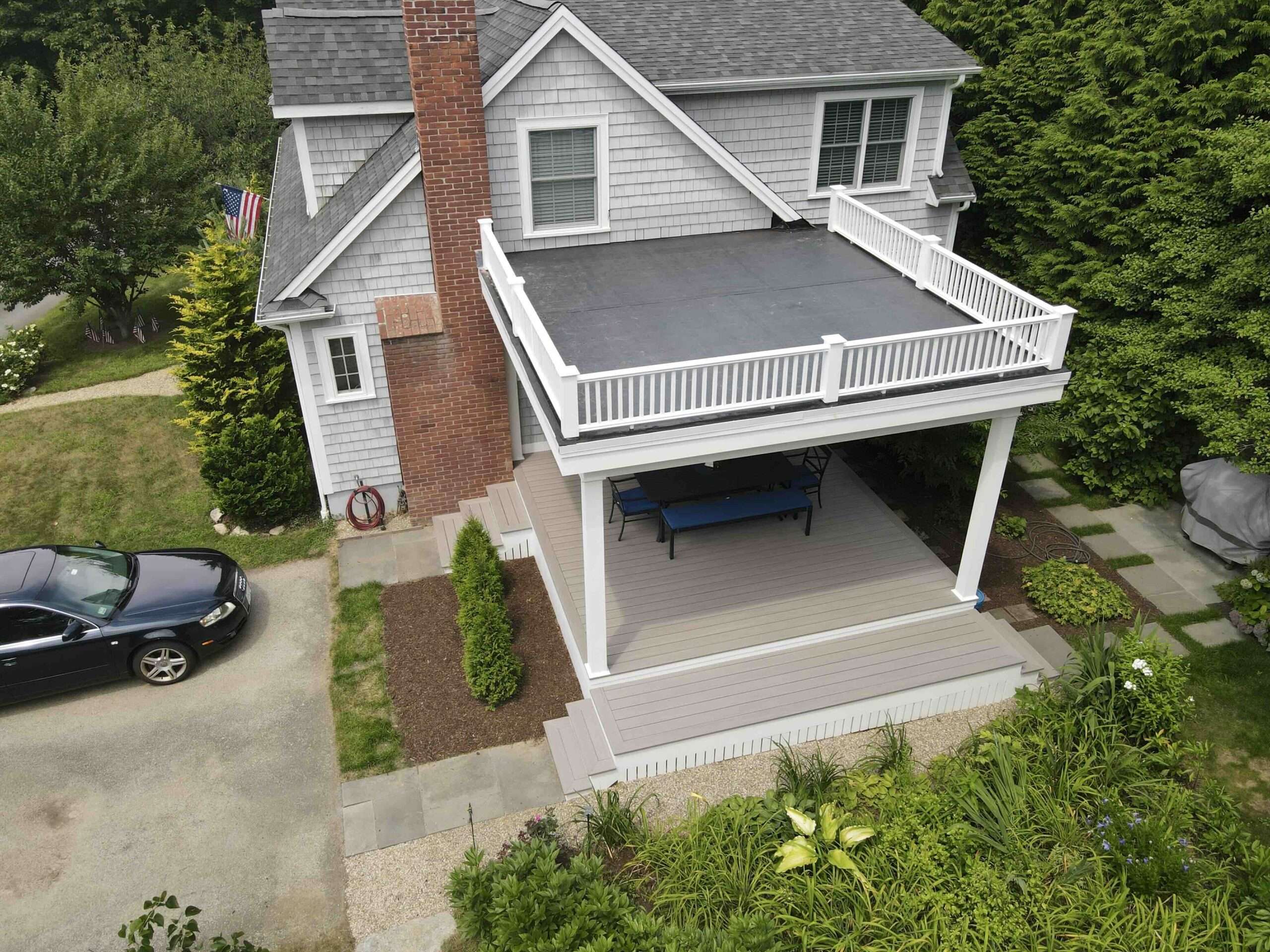 aerial-view-of-the-commercial-under-deck-with-white-railing-and-outdoor-furniture-featuring-trees-and-grass-on-the-background-in-worcester-ma.jpeg