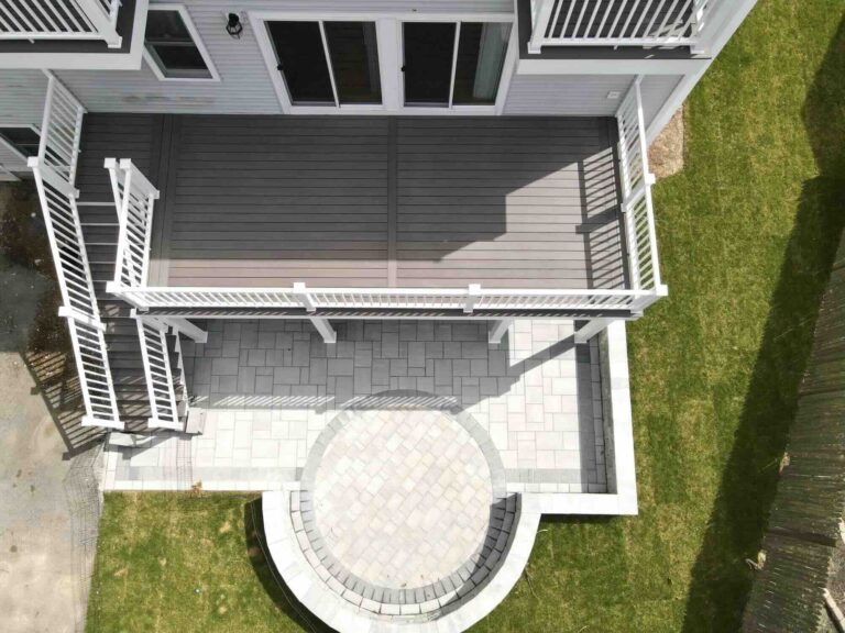 aerial-view-of-the-elevated-residential-deck-with-white-railing-and-paver-patio-in-worcester-ma.jpeg