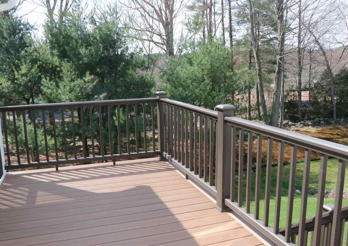 composite-deck-repair-installation-with-railing-and-trees-on-the-background-in-worcester-ma.jpg