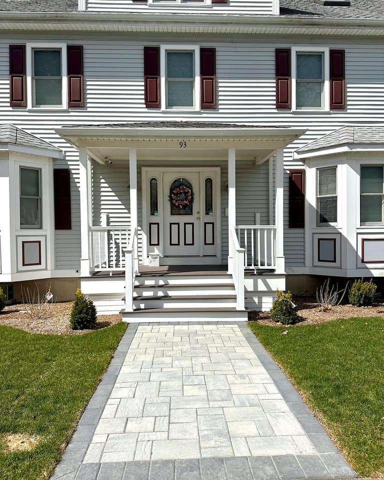 Patio with front porch on the big house with white aluminum railing in worcester ma