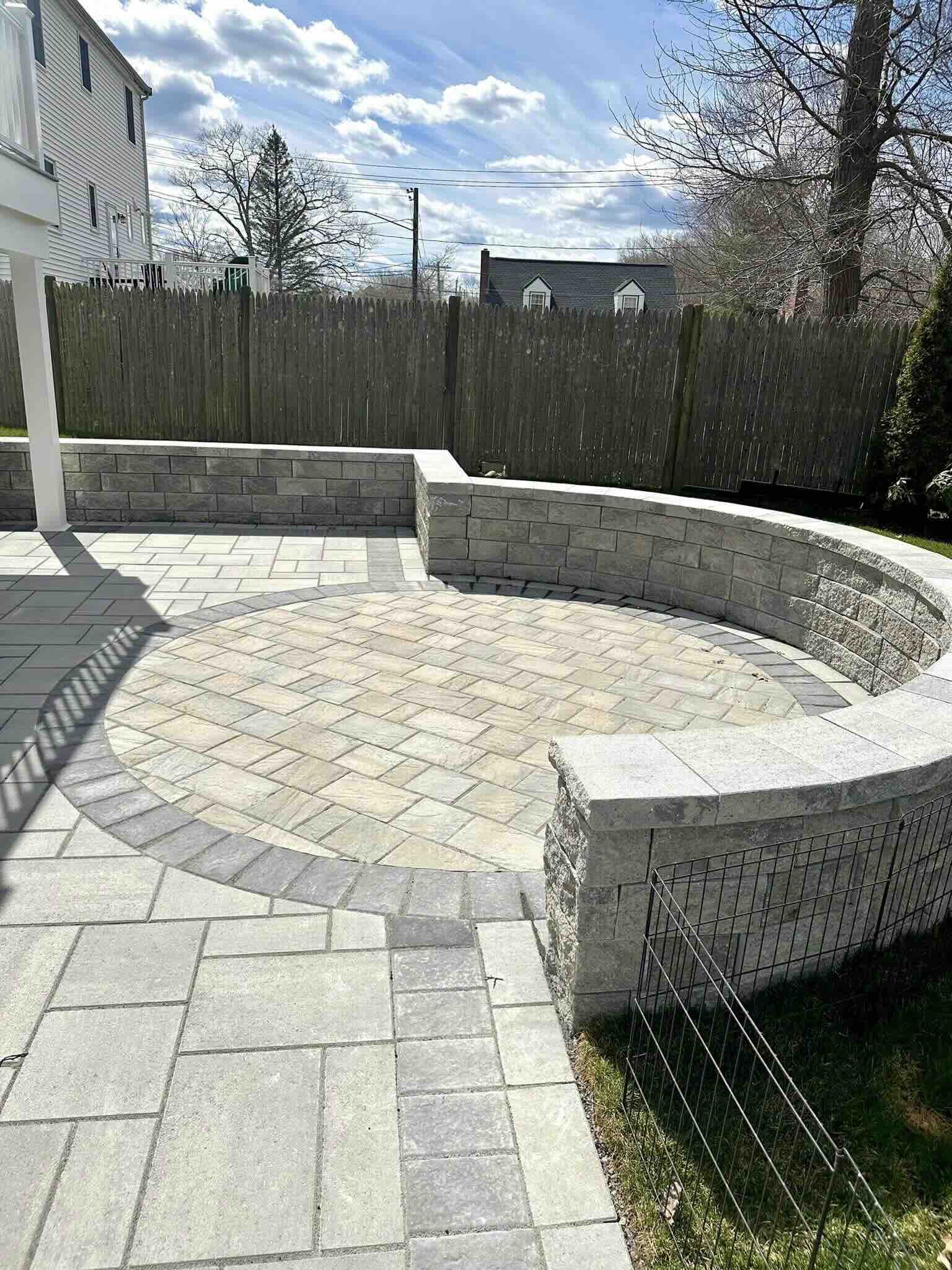 Paver patio with bench and wooden big fence in worcester ma