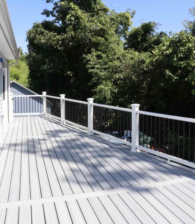 Pvc deck with black balusters railing featuring trees on the background in worcester ma