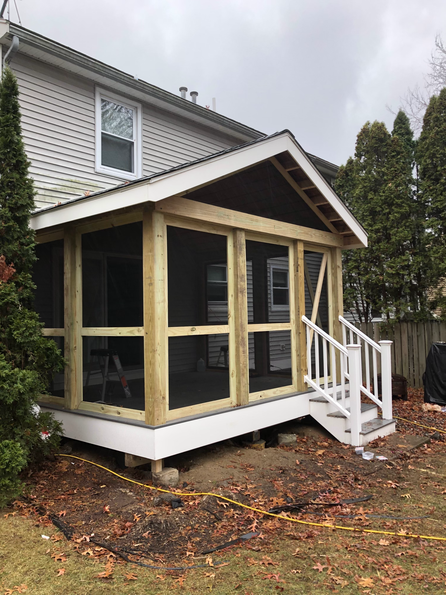 Raised commercial deck with small stairs and white railing on screened in porch in worcester ma