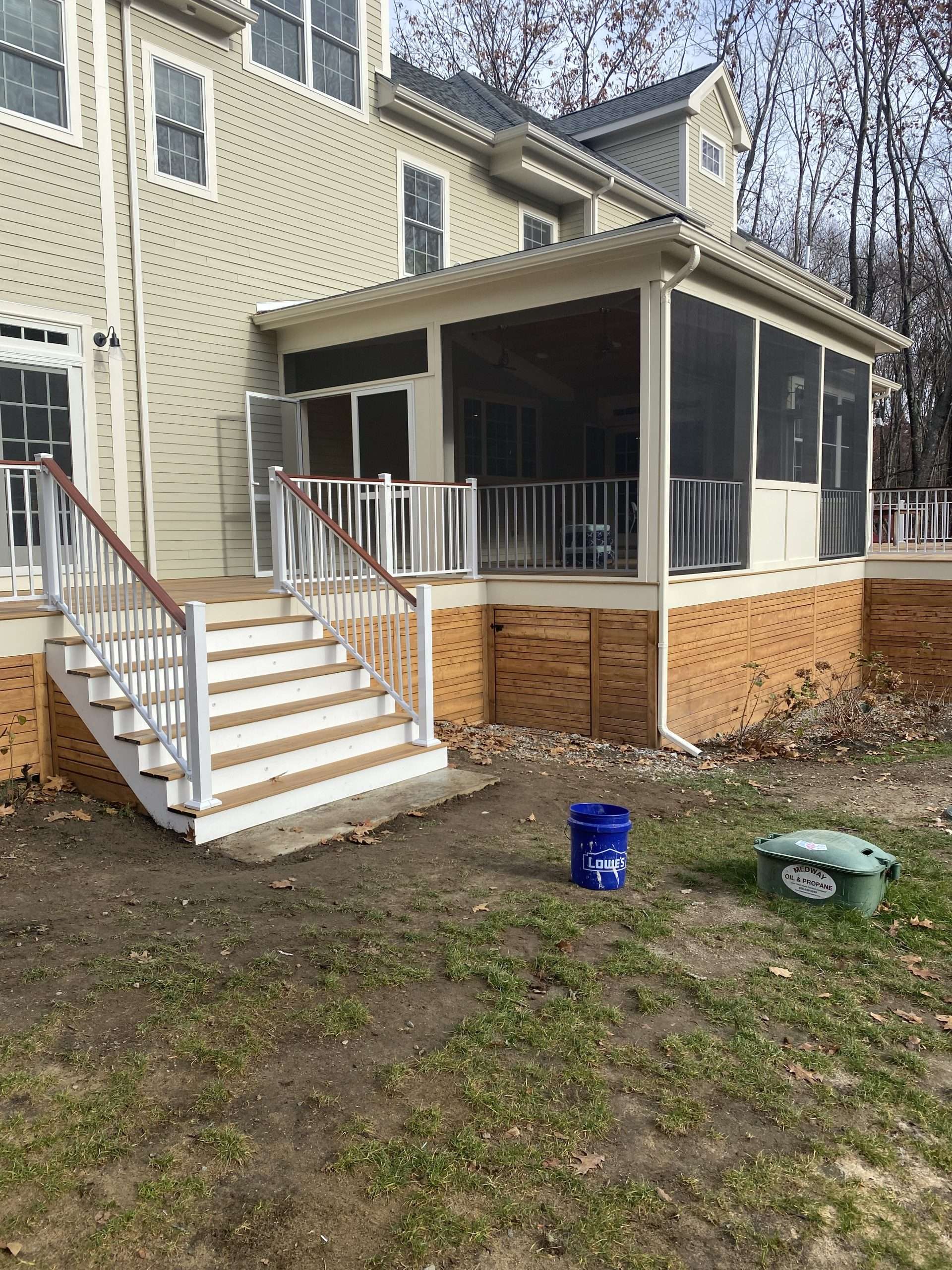 Raised deck with screened in porch on a mocha house with white balusters in worcester ma
