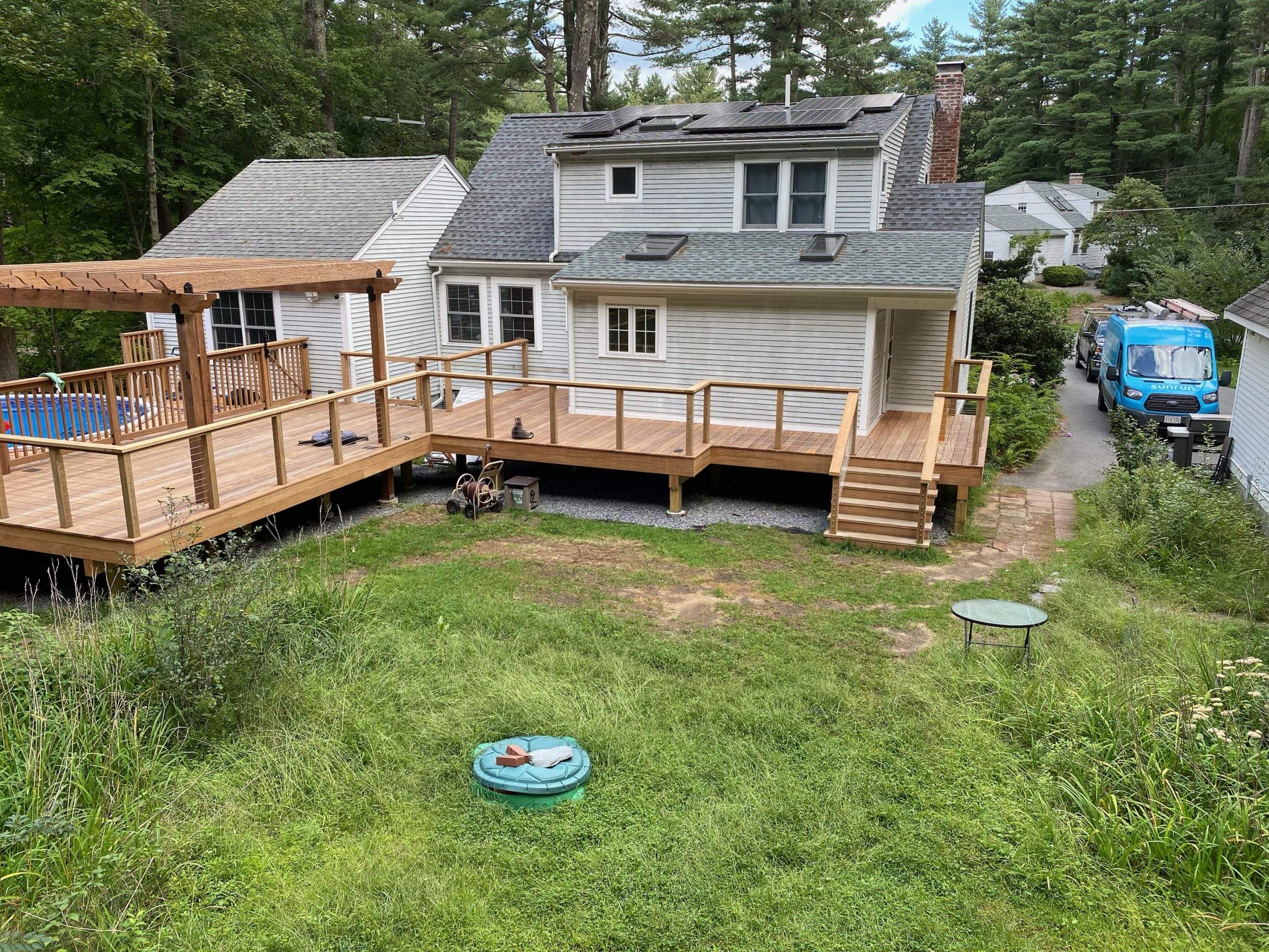 Raised wooden deck with cable railing and a gate with pool in worcester ma