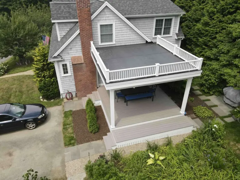 Residential under deck with white railing and outdoor furnitures below the deck in worcester ma
