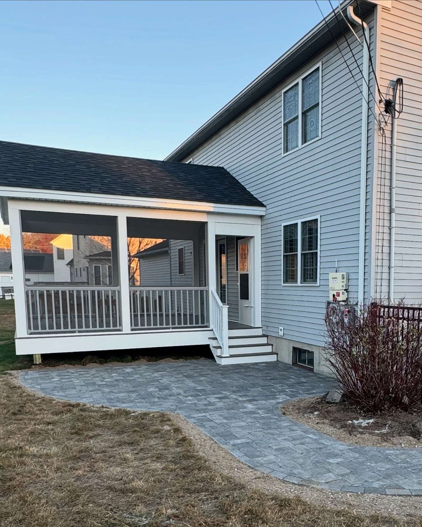 Screened in porch installation with white railing on the raised deck in worcester ma
