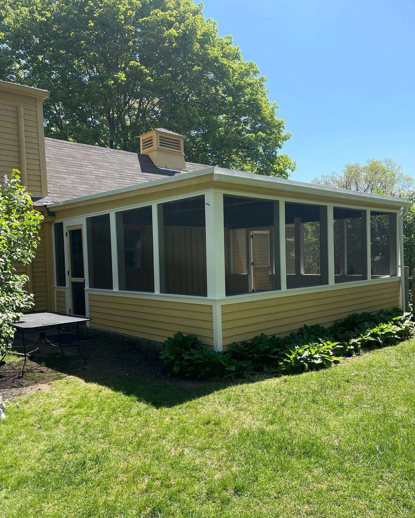 Screened in porch on the ground with plants beside it on the outside in worcester ma